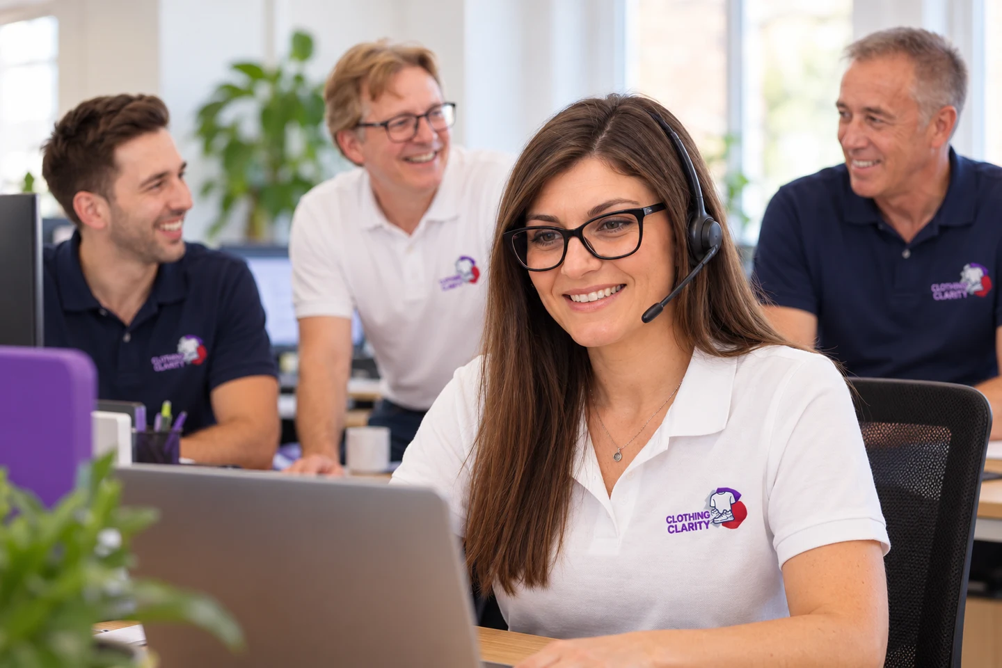 Katie helping at a laptop, with Michael, Matthew and Adam in the background