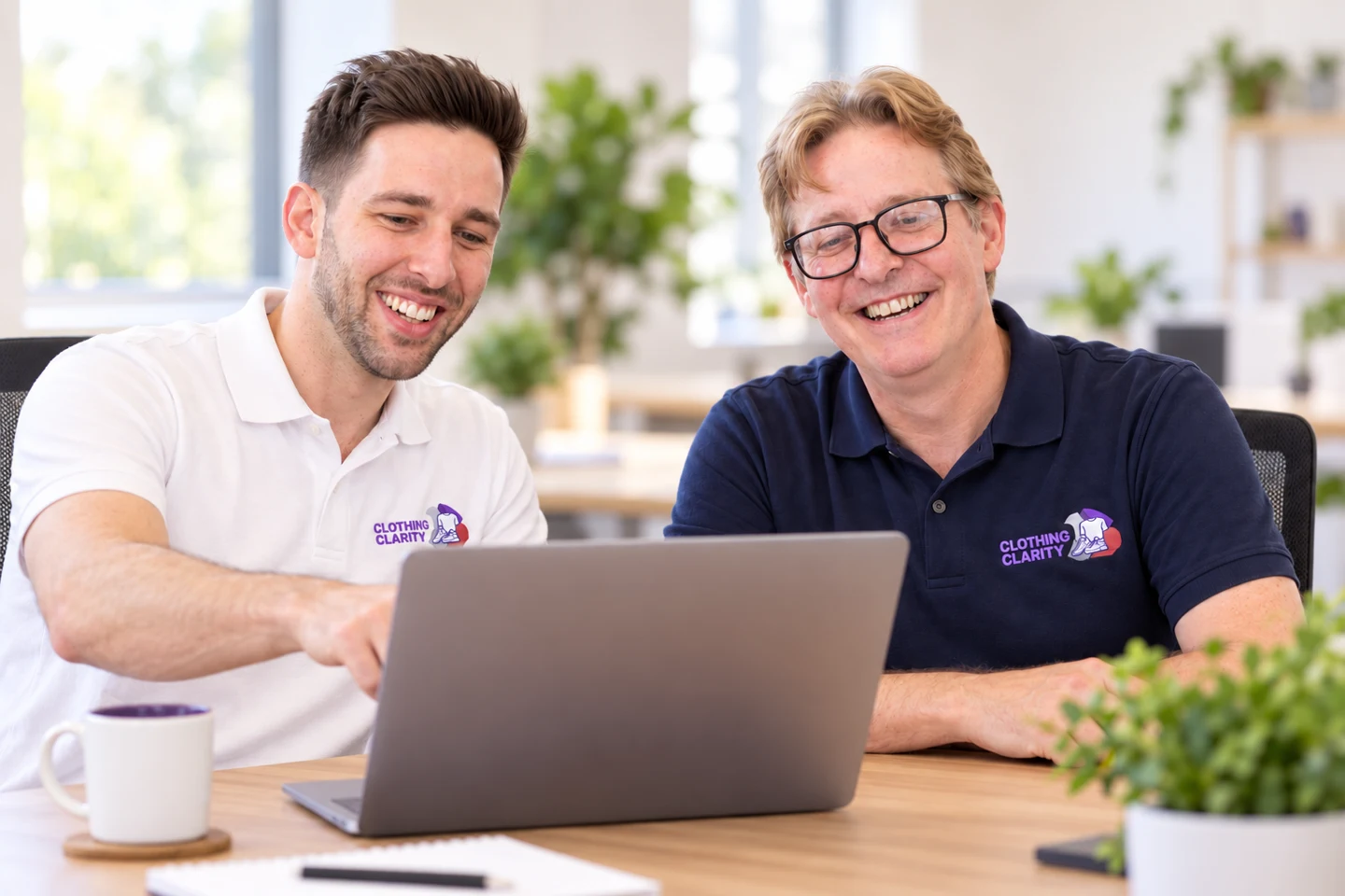 Matthew and Adam together at a laptop, providing personal Clothing Clarity training